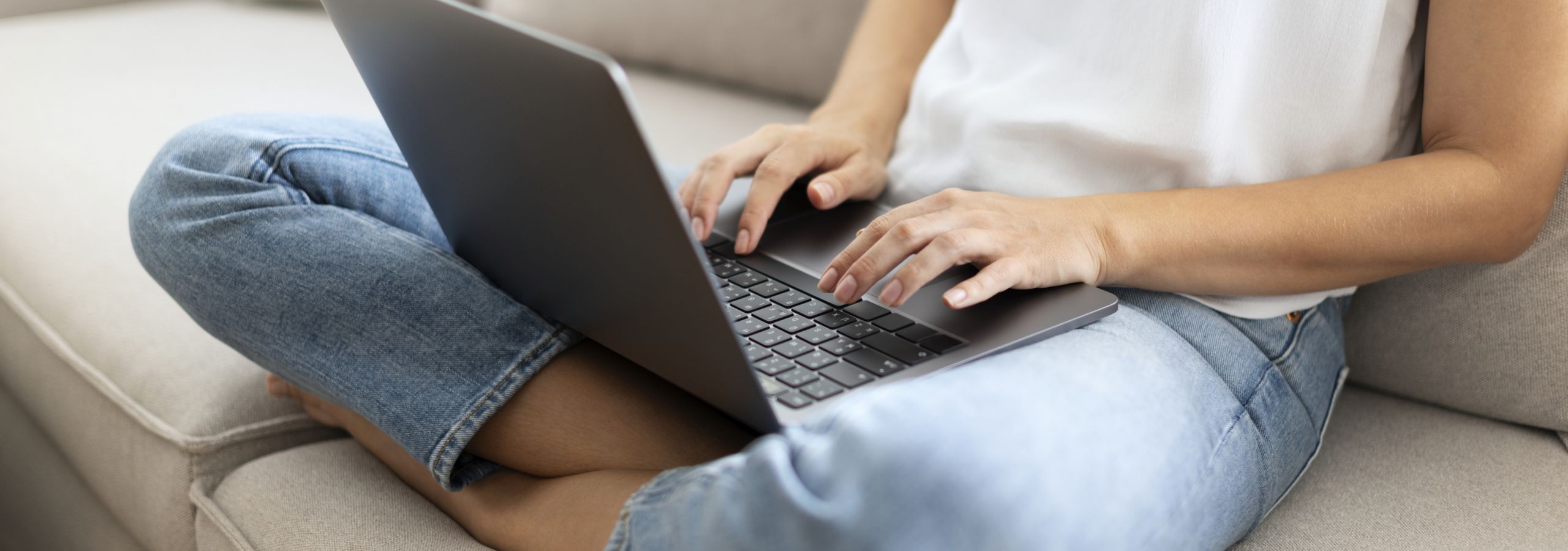 woman typing on computer on couch
