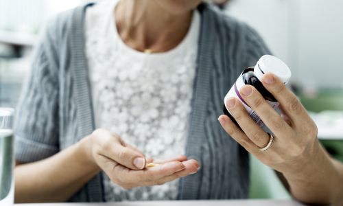 woman holding a pill bottle 